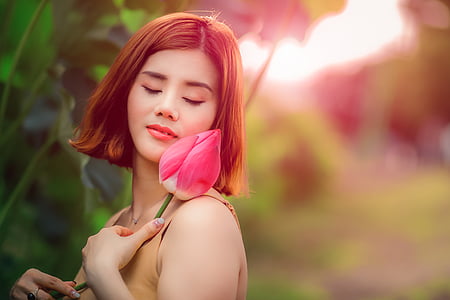 woman holding pink flower photo taken during daytime thumbnail