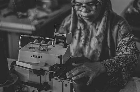grayscale photography of woman sewing clothes thumbnail