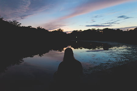 silhouette photography of person facing body of water under cirrus clouds and blue calm sky thumbnail