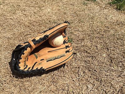 white baseball inside brown Mizuno baseball mitt thumbnail