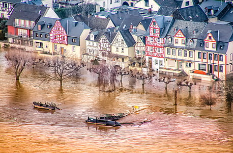 three black ships on water near houses thumbnail