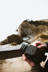 person holding black camera thumbnail