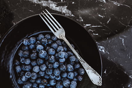 Fresh blueberries on a black plate with vintage cutlery thumbnail