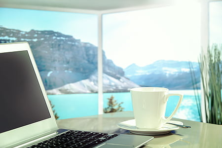 white ceramic mug beside laptop computer on table thumbnail