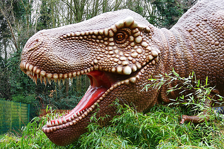 brown T-rex statue near trees at daytime thumbnail