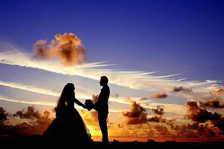 silhouette of couple standing under the clouds thumbnail