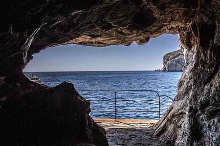cave near body of water during daytime thumbnail