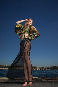 woman wearing green and black long-sleeved crop-top standing near ocean thumbnail