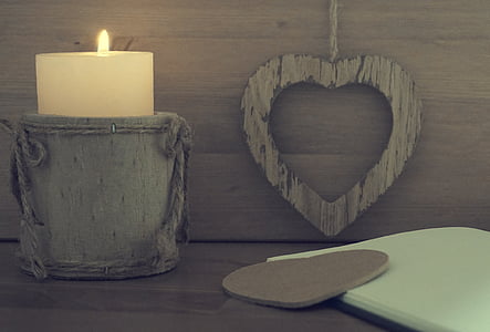 lighted candle in holder beside wall thumbnail