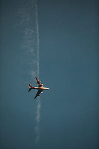 white and red passenger plane flying under blue sky during daytime thumbnail