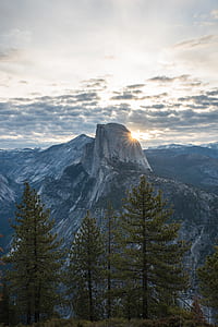 landscape photography of mountain range near green trees under clear blue sky thumbnail