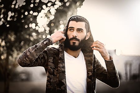 Man Wearing Camouflage Hoodie and White Shirt thumbnail