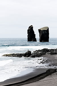 two rocks surrounded by body of water thumbnail