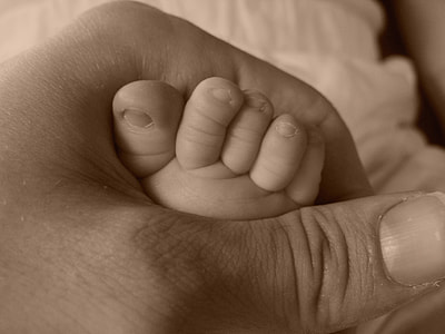 person holding feet of baby thumbnail