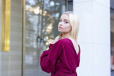 blonde-haired woman wearing purple dress standing outside clear glass door thumbnail