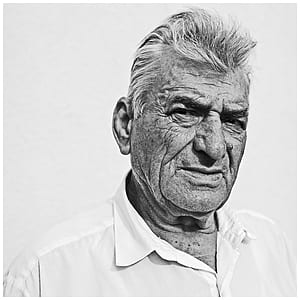 man wearing white dress shirt standing near wall thumbnail