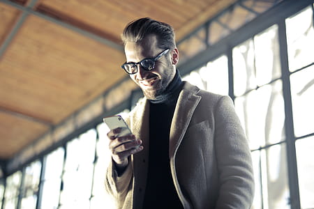 Young Adult Man smiling as he looks on his cellphone thumbnail