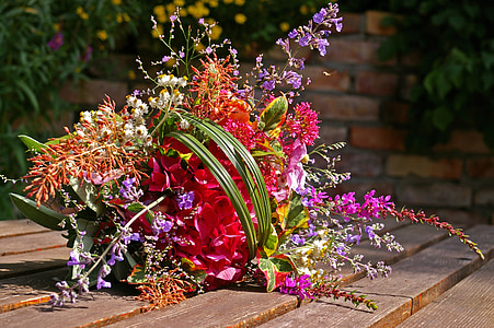 assorted-color petaled flowers arrangement on brown table thumbnail