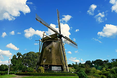 Brown and Black Windmill Under Cumulus Clouds Surrounded by Green Leaf Trees thumbnail