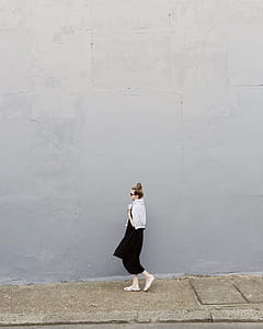 Woman Wearing Black Maxi Dress and Pair of White Flats Standing Beside Gray Wall thumbnail