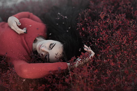 woman wearing red sweater lying on red leaf plants thumbnail