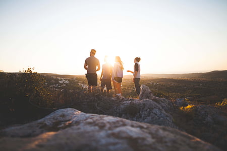 four person standing near grass at daytime thumbnail
