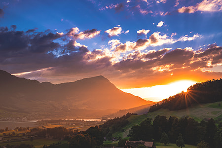 sun rays shining upon mountain and hill thumbnail