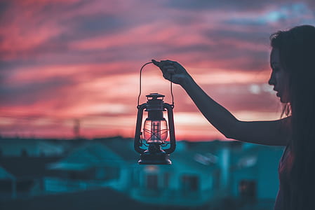 selective focus photography of woman holding cold-blast lantern thumbnail