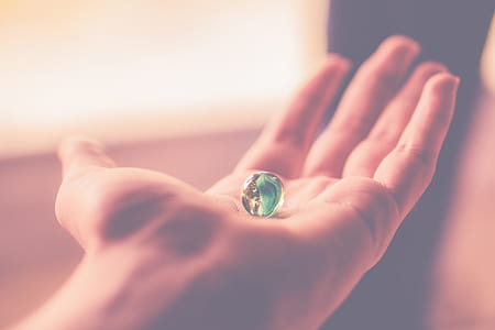 person holding toy marble during daytime thumbnail