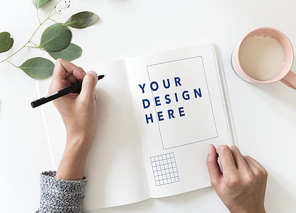 person holding black pen about to write on white book thumbnail