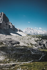 rocky mountain with mountain filled with snow under blue sky thumbnail