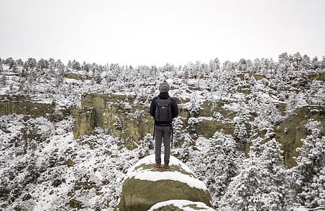 person standing on gray rock formation thumbnail