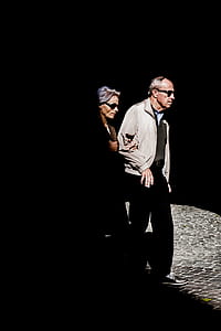 man and woman walking along dark path thumbnail