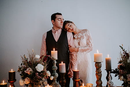man and woman standing near candles thumbnail