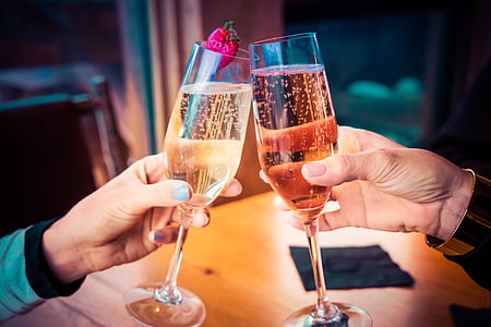 two people holding glass wine filled with white liquid thumbnail