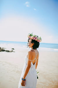 woman in white dress with head dress standing on shore thumbnail