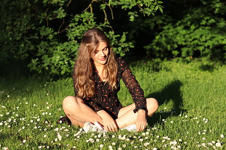 Woman Wearing Red and Brown Mesh Dress Shirt Sits on White Flower Field thumbnail