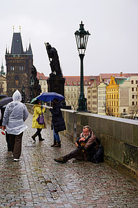 man sitting on the side of bridge with people walking during daytime thumbnail