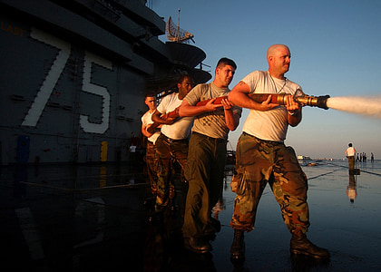 four man holding hose under blue sky thumbnail