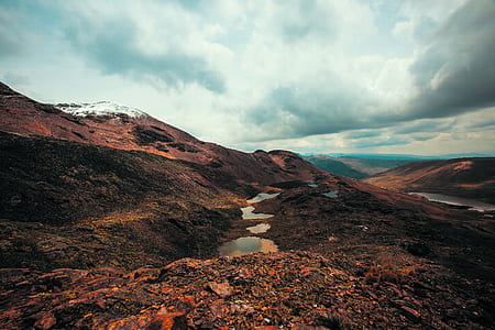 aerial view of body of water in the middle of hill thumbnail