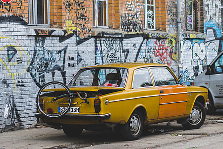 brown coupe parked near wall with graffiti thumbnail