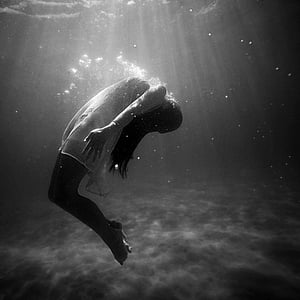 grayscale photography of woman floating underwater thumbnail