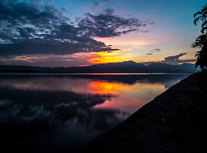silhouette of mountains between lake during golden hour thumbnail