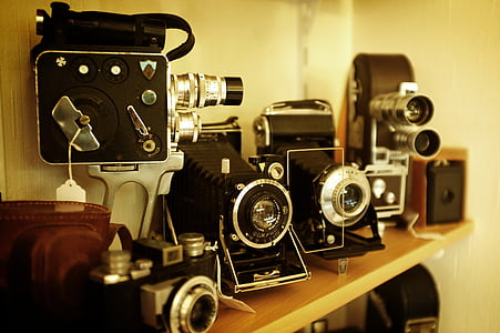 black land cameras on brown wooden rack thumbnail