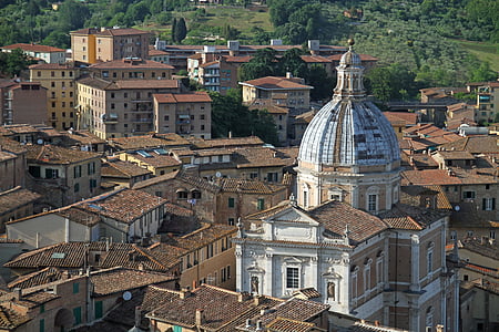 white and brown cathedral surrounded by houses thumbnail