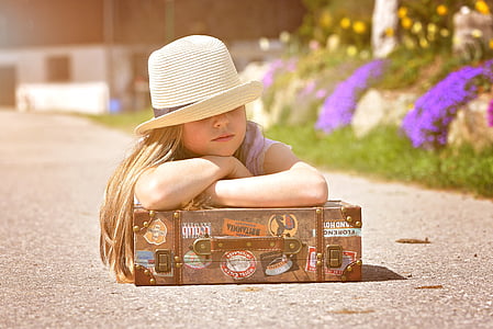 girl leaning on suitcase during daytime thumbnail