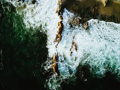 low angle photography of cliff with ocean thumbnail