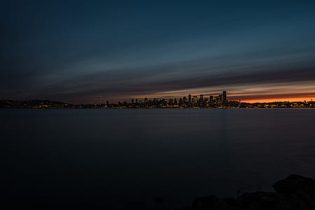 silhouette of buildings near body of water thumbnail
