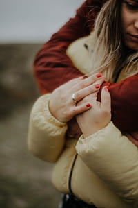 person hugging woman wearing silver-colored band ring thumbnail