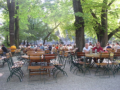 people sitting on benches under trees outdoor thumbnail